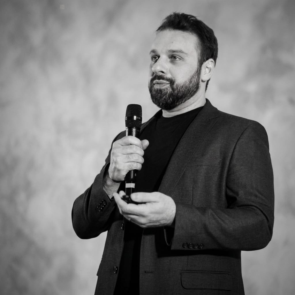 Portrait of Dr. Manoel Acioli speaking into a microphone